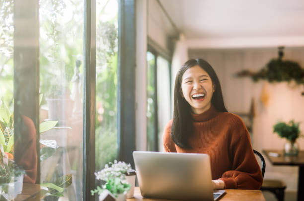 Happy young asian girl working at a coffee shop with a laptop Aloe Mind Malaysia | Mental Healthcare Services in Malaysia and Singapore